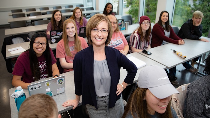 Hospitality leadership department head Stephanie Hein with students in classroom.