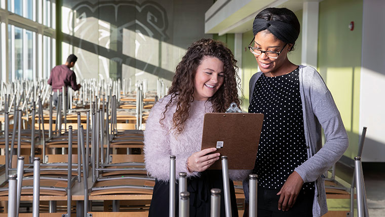 Hospitality leadership students reviewing items on a clipboard within a Missouri State classroom