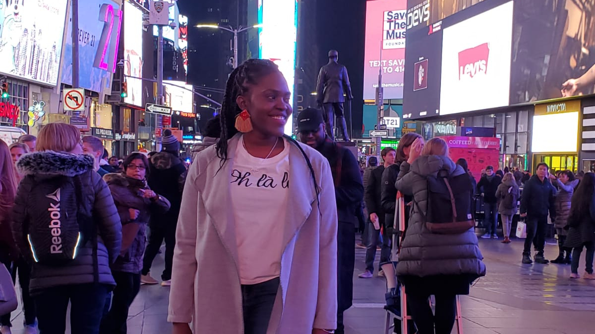 Hospitality student standing in Times Square.