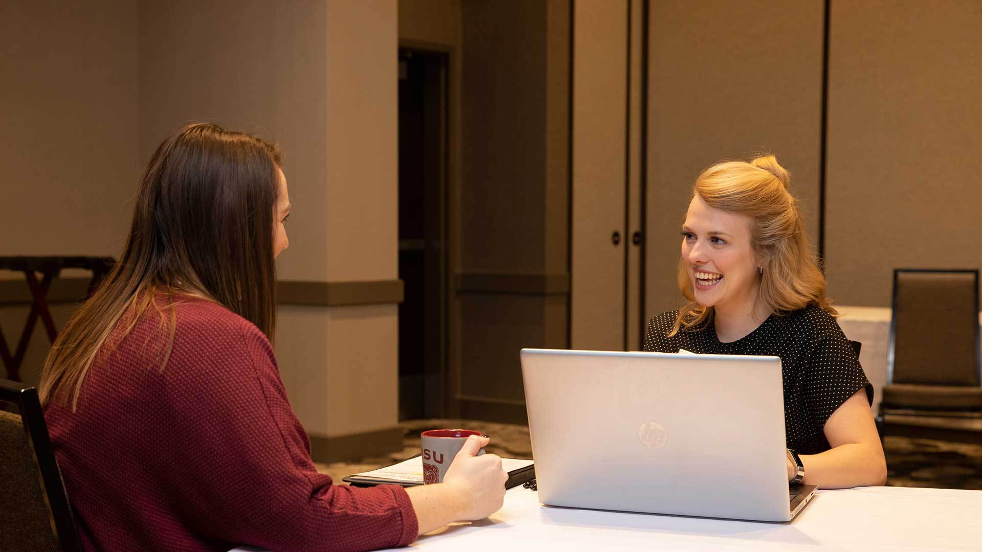 Hospitality student talking with hotel manager.